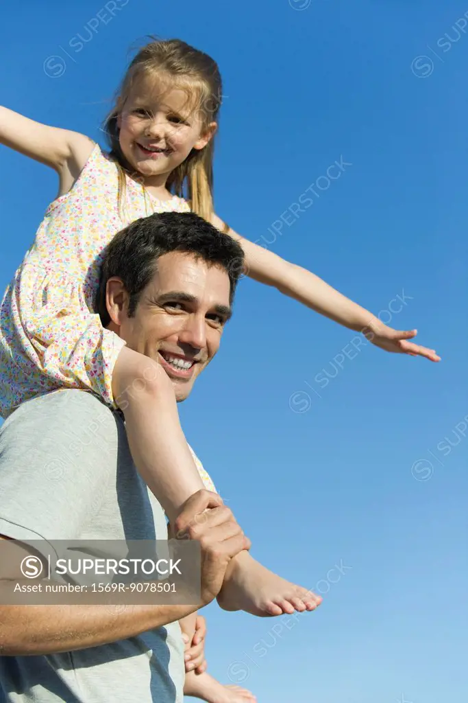 Father carrying daughter on his shoulders