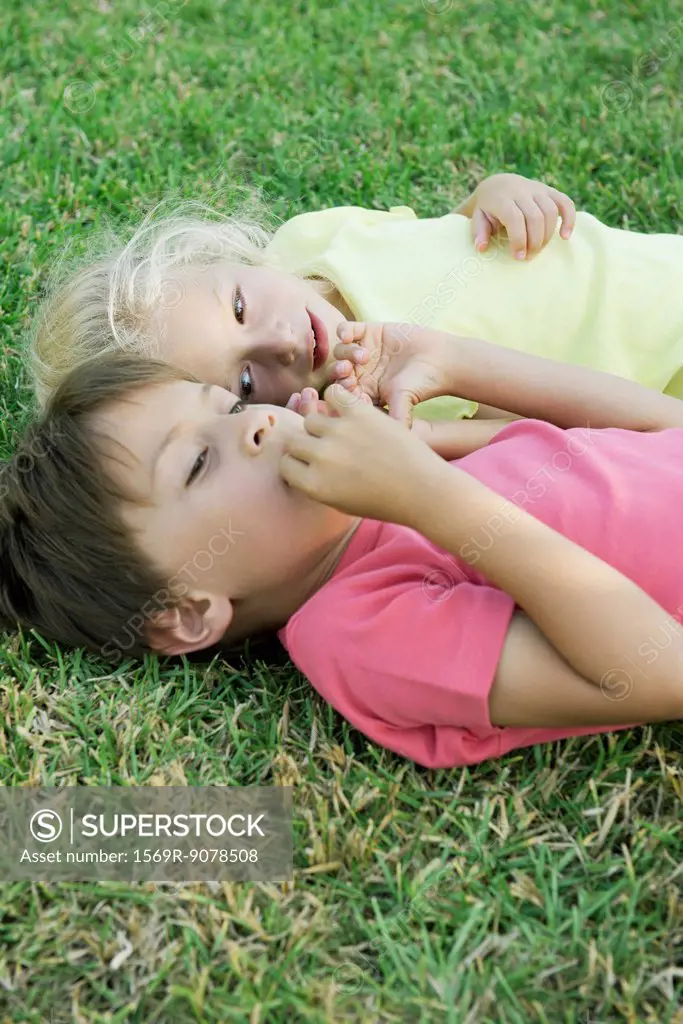 Young friends lying together on grass