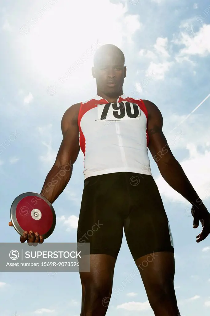 Male athlete holding discus, low angle view
