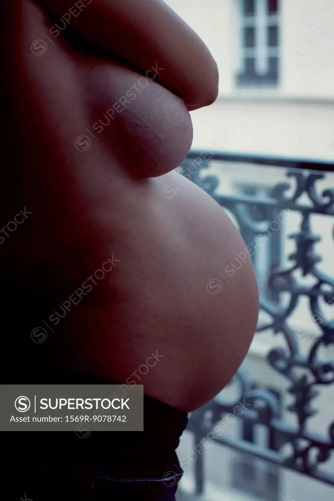 Semi_naked pregnant woman, mid section, side view