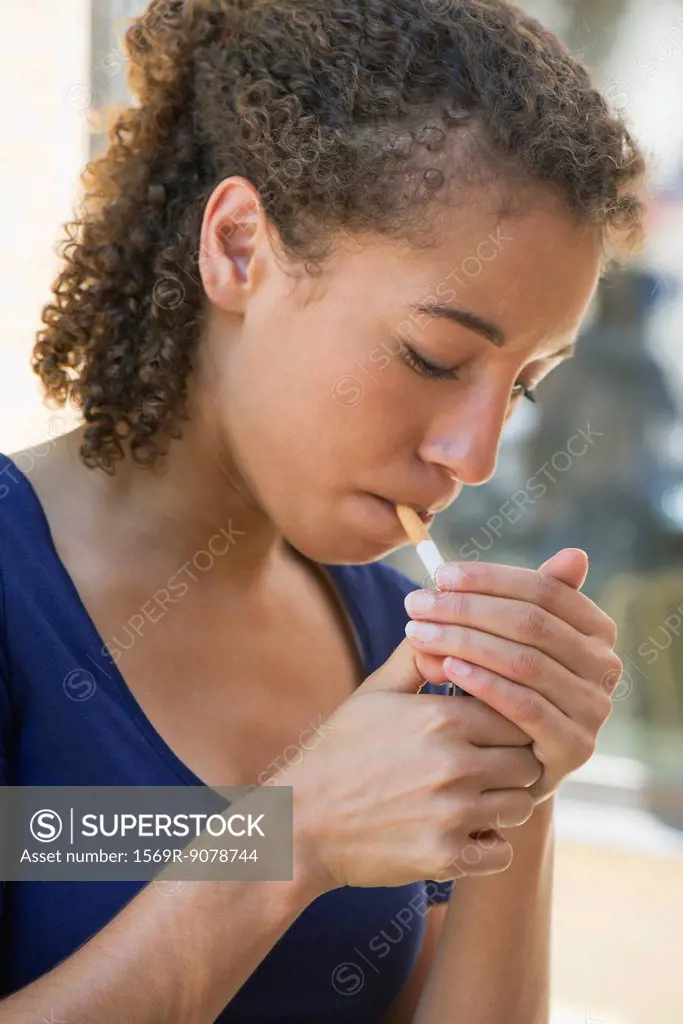 Young woman lighting cigarette