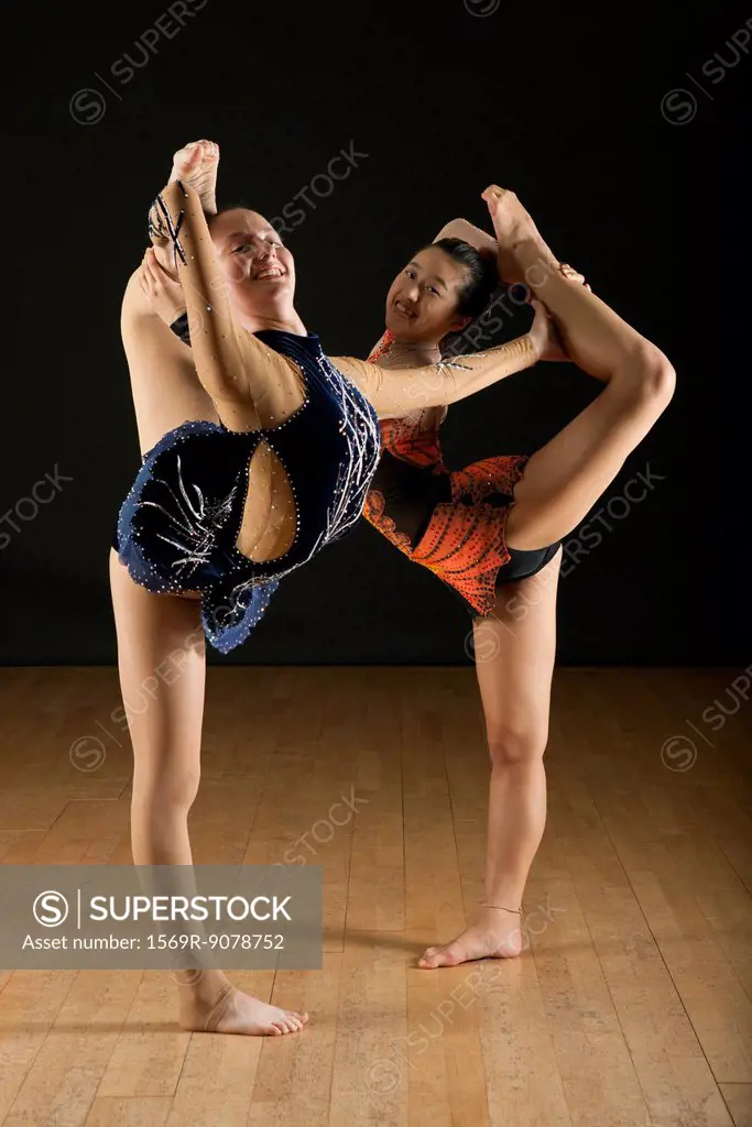 Gymnasts performing standing splits together, portrait