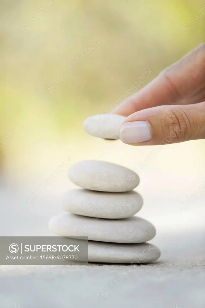 Hand stacking pebbles