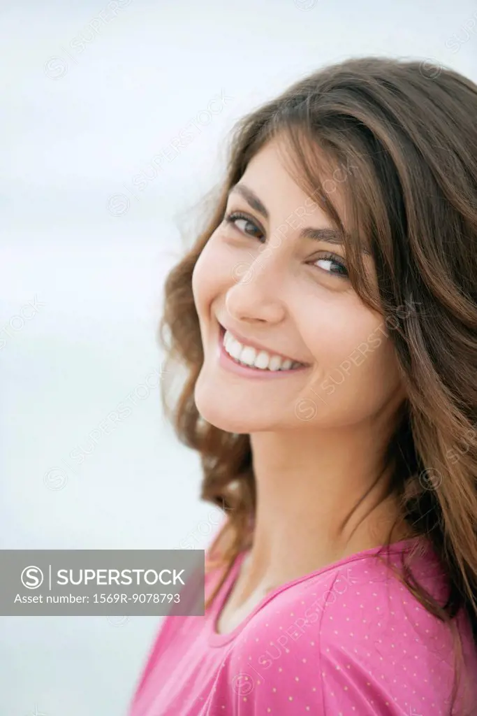 Young woman smiling over shoulder, portrait