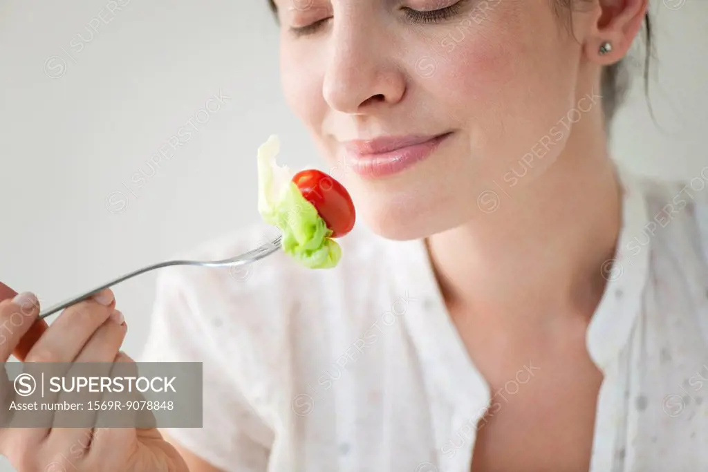 Mid_adult woman enjoying fresh vegetables