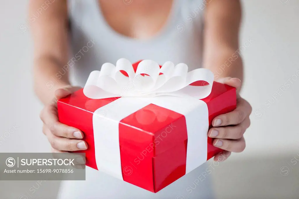 Woman holding gift box, cropped