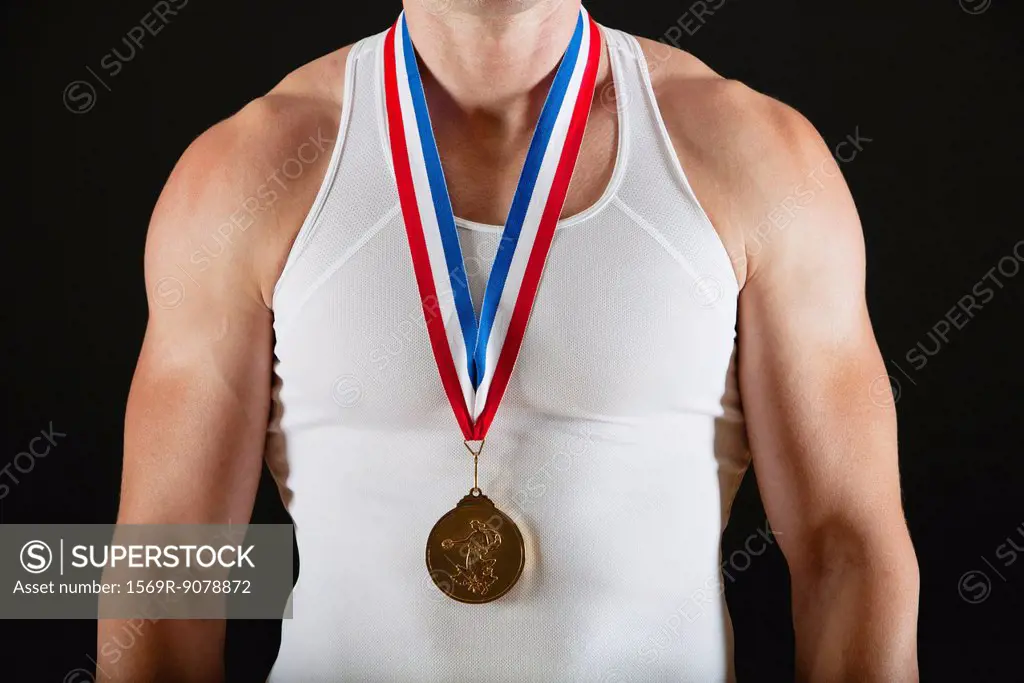 Male gymnast with gold medal, mid section