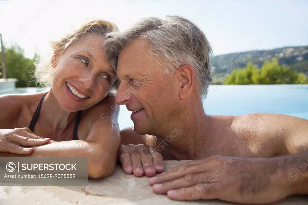 Mature couple relaxing together in pool