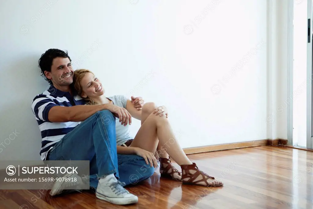 Couple sitting on hardwood floor