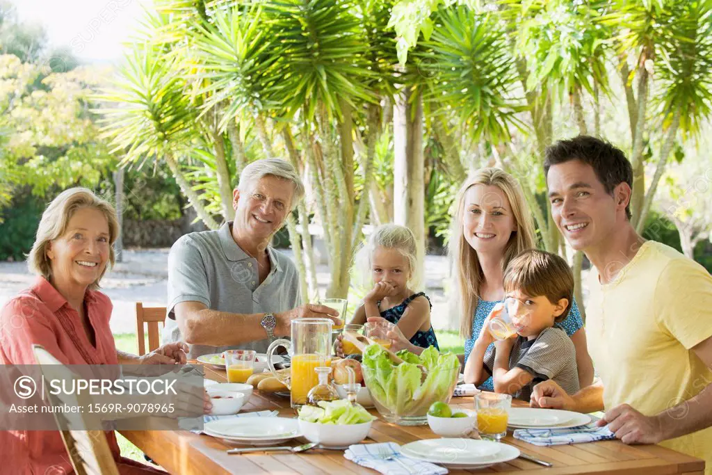 Multi_generation family at breakfast table outdoors, portrait