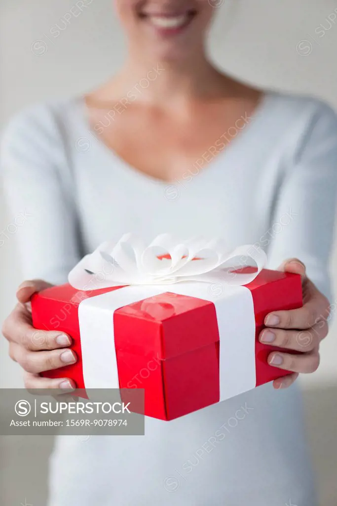 Woman holding gift box, cropped