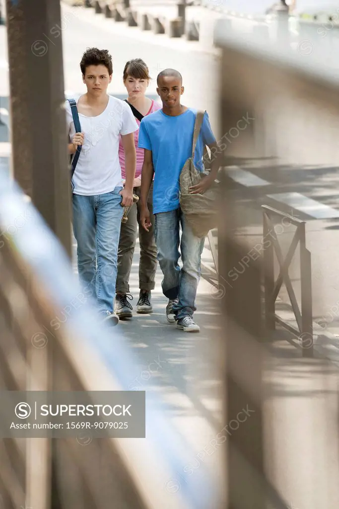 Young people walking on sidewalk