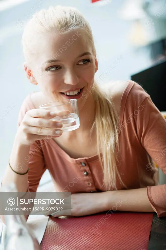Young blond woman drinking water