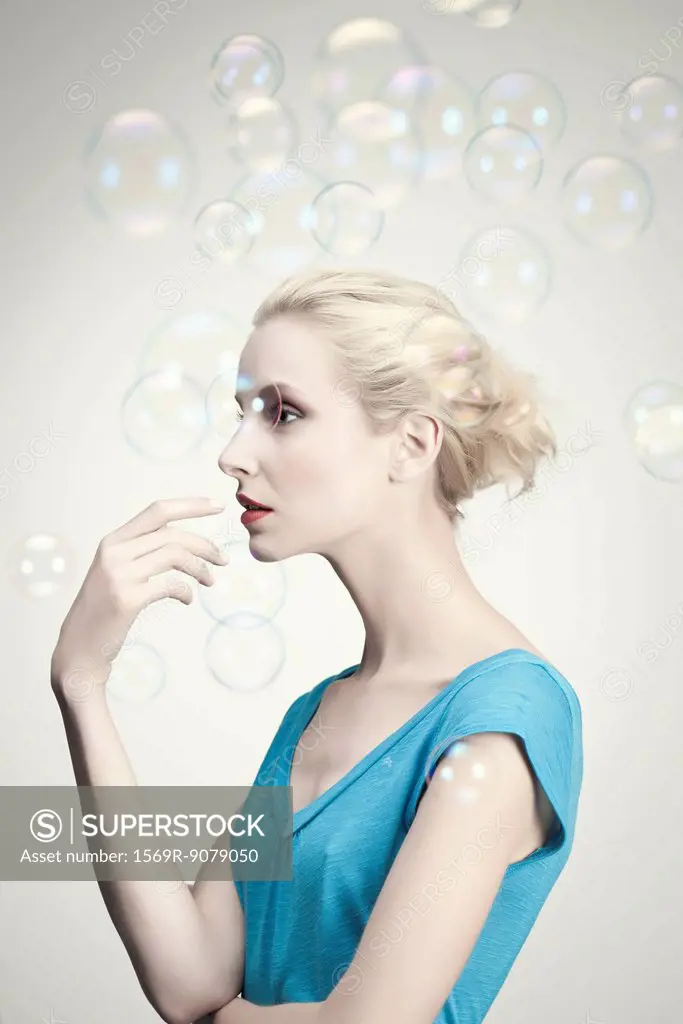 Young woman surrounded by bubbles, portrait