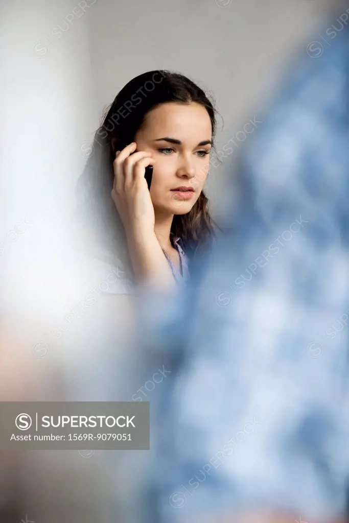 Young woman using cell phone with concerned expression