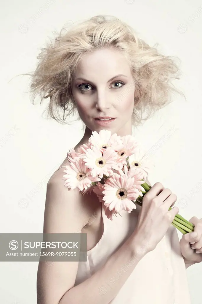 Young woman holding bunch of gerbera daisies, portrait