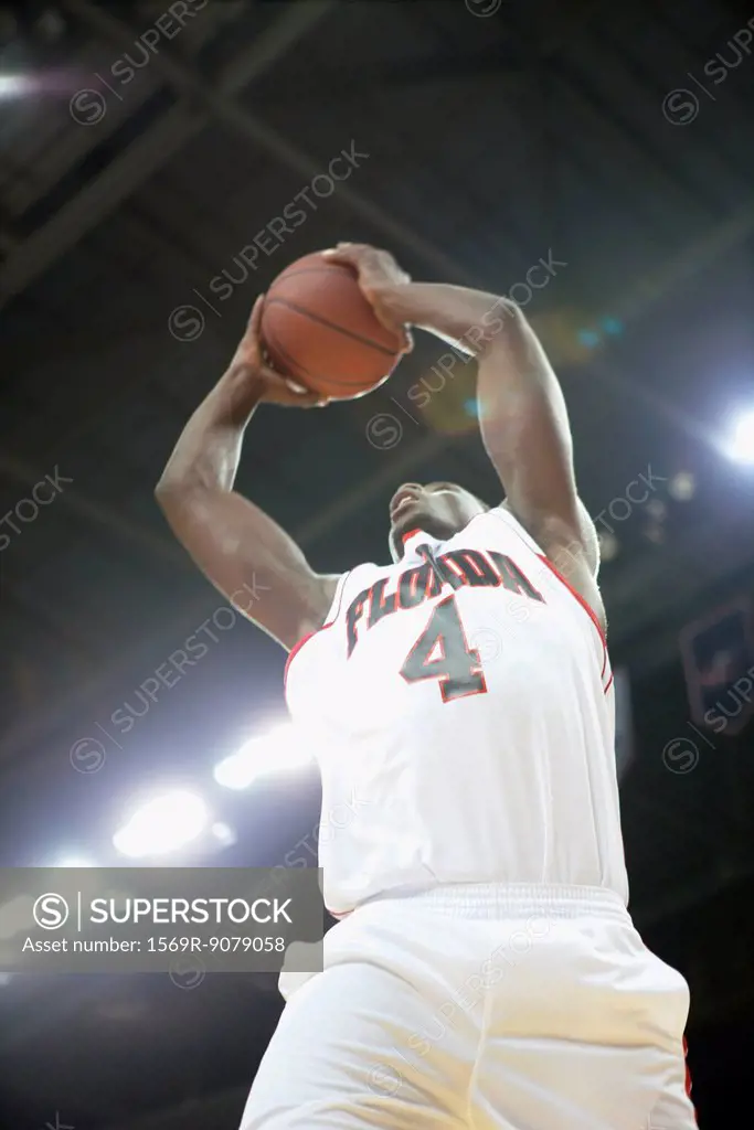Basketball player jumping with basketball, low angle view