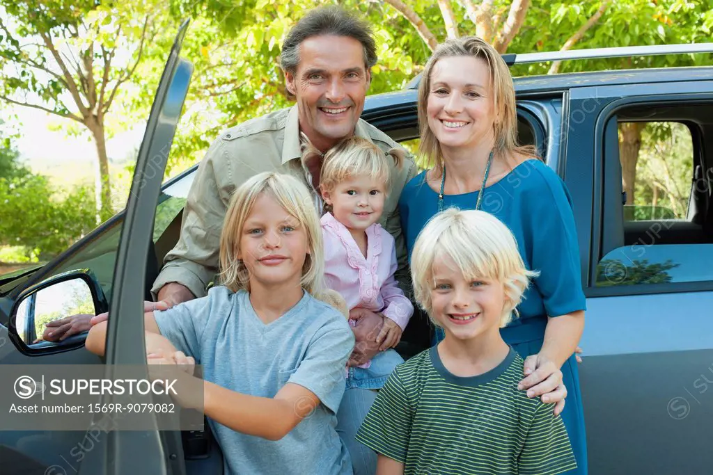Family posing beside car, portrait