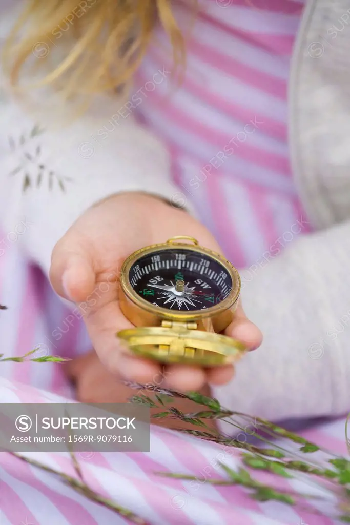 Girl holding compass, cropped