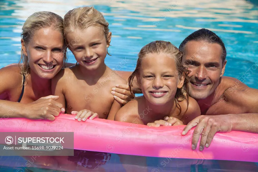 Family relaxing together in pool, portrait