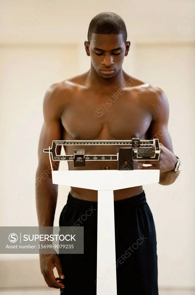 Young man standing on weight scale