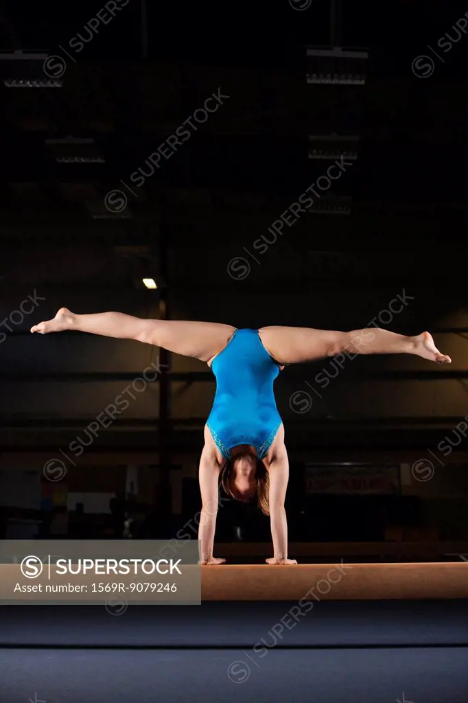 Gymnast doing handstand with legs split