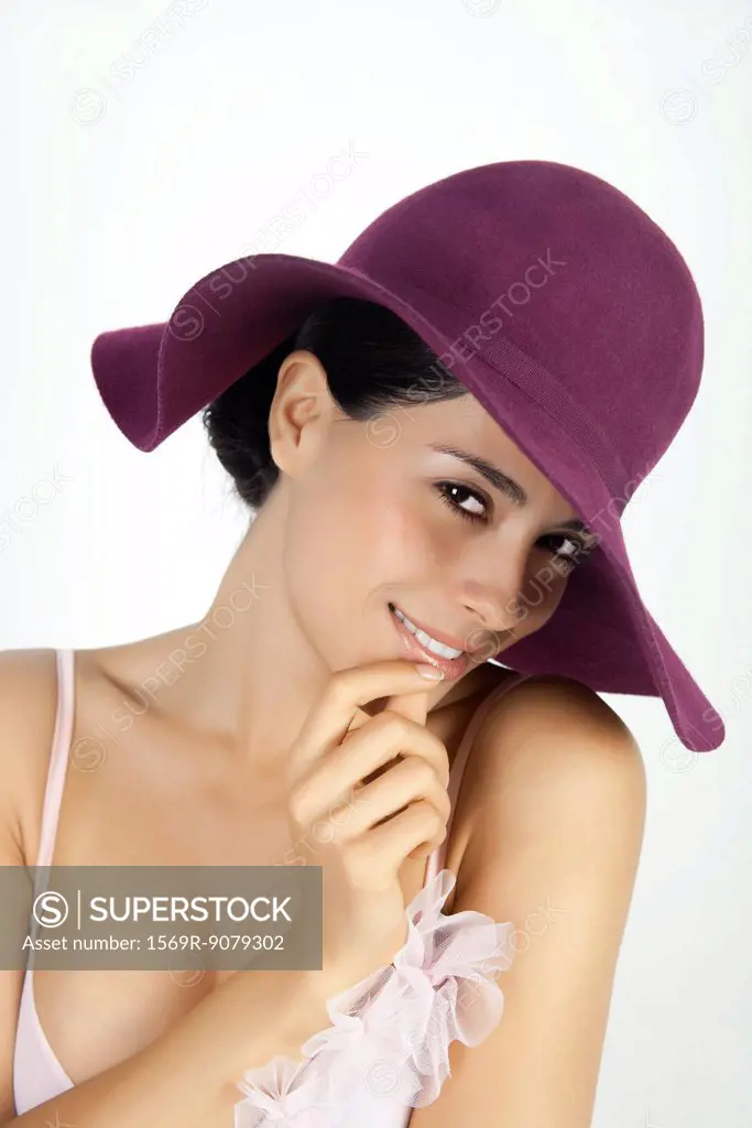 Woman wearing hat, smiling coyly at camera, portrait