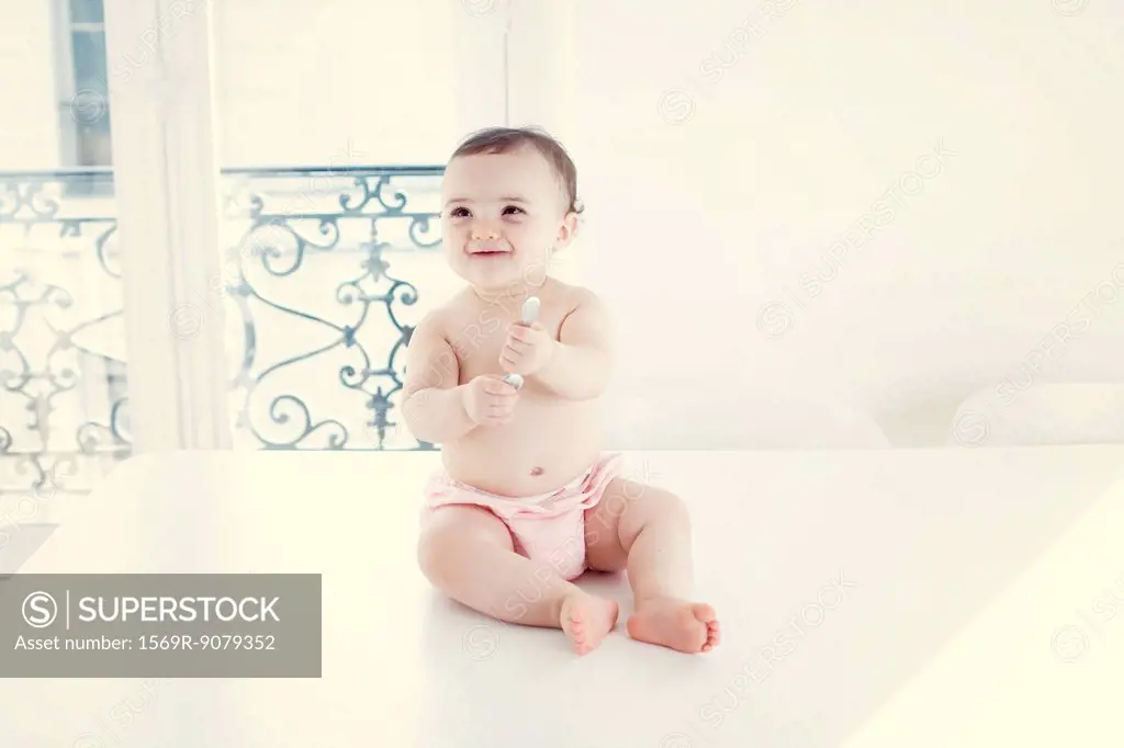 Infant playing with spoon, portrait