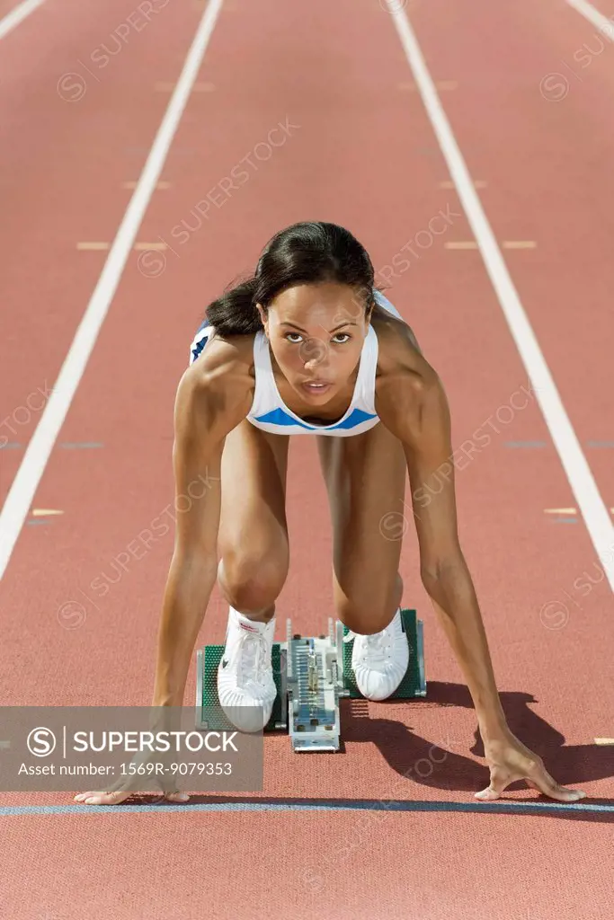 Woman crouched in starting position on running track