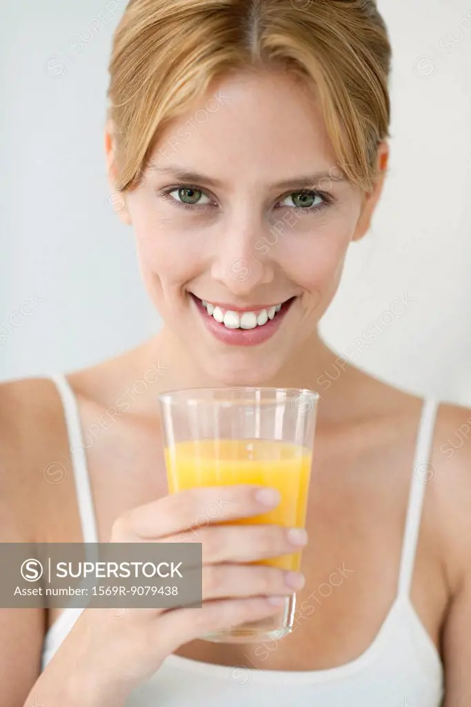 Young woman with glass of orange juice, portrait