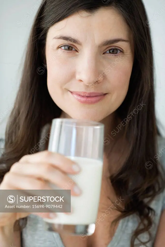 Mid_adult woman holding glass of milk