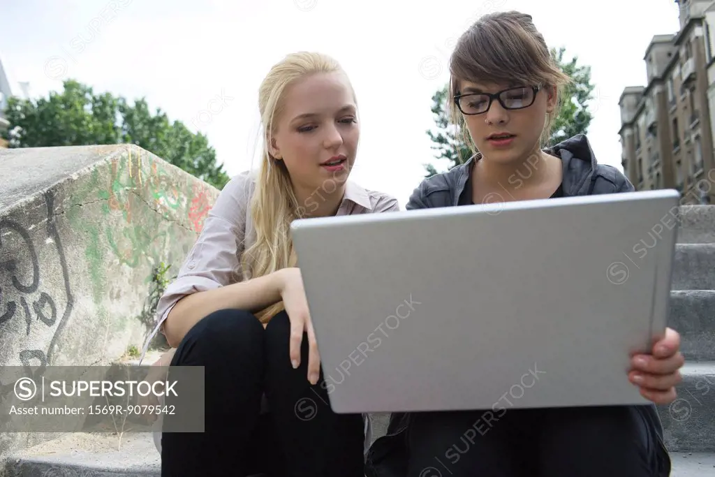 Young women using laptop computer outdoors