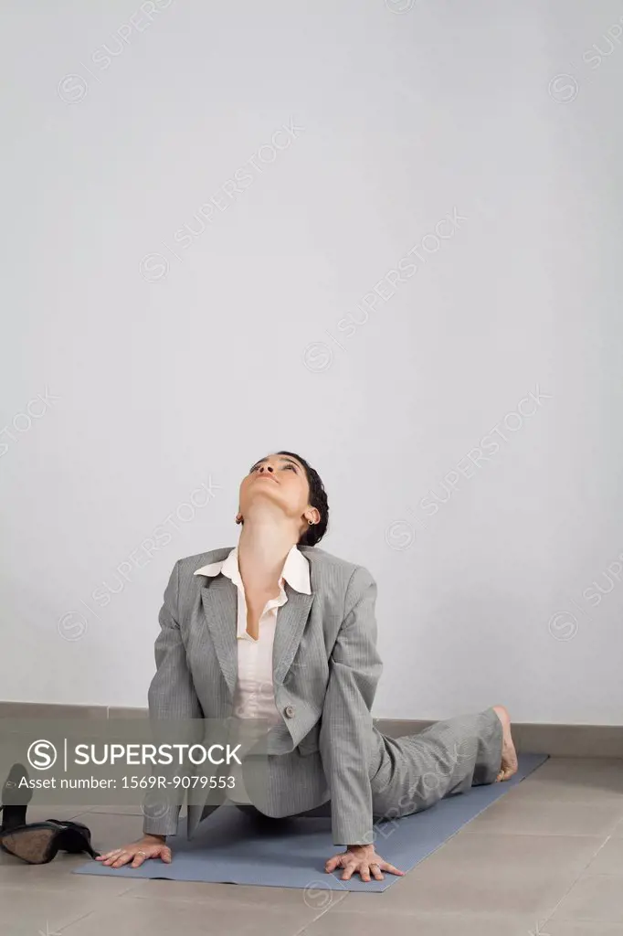 Businesswoman doing cobra pose in office