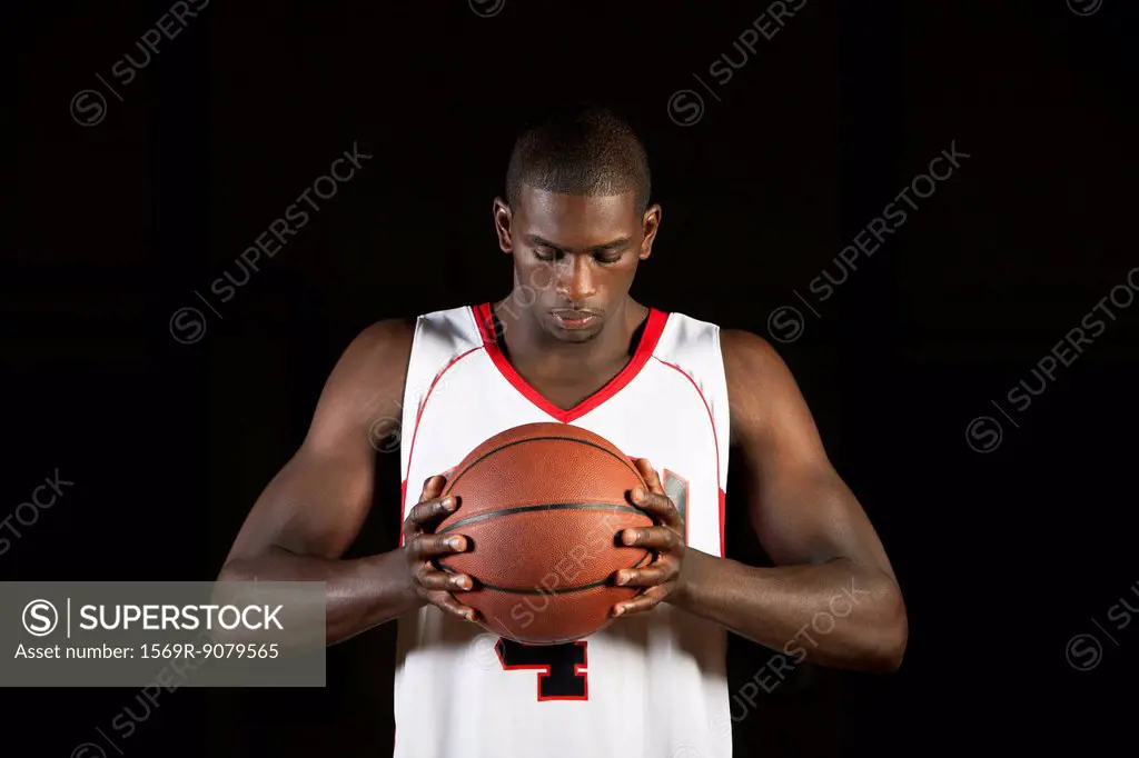 Basketball player holding basketball, portrait