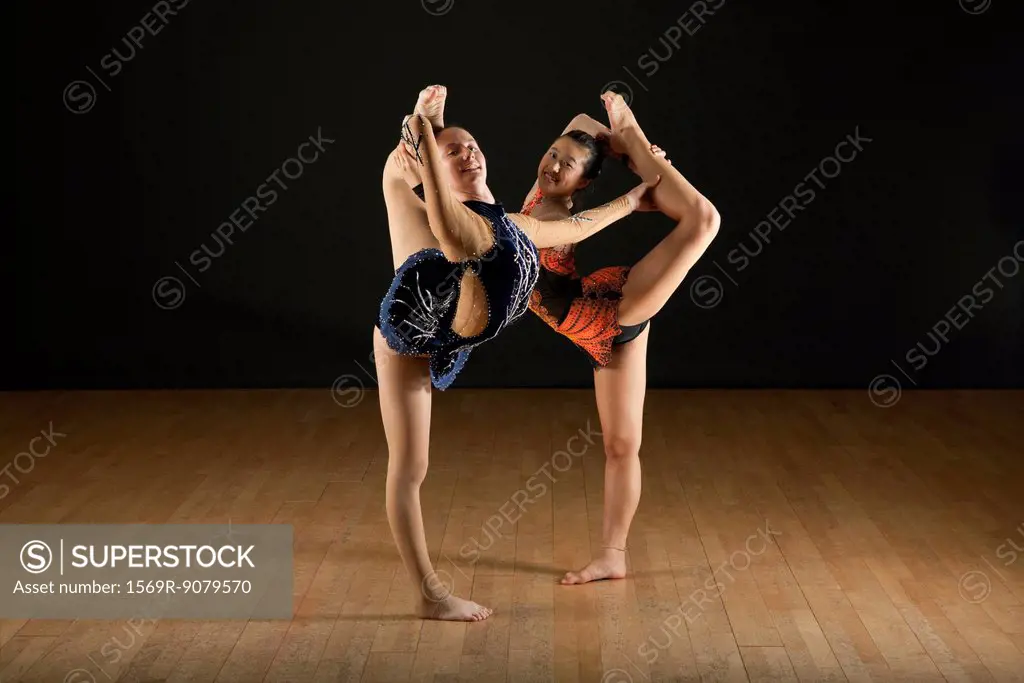 Gymnasts performing standing splits together, portrait