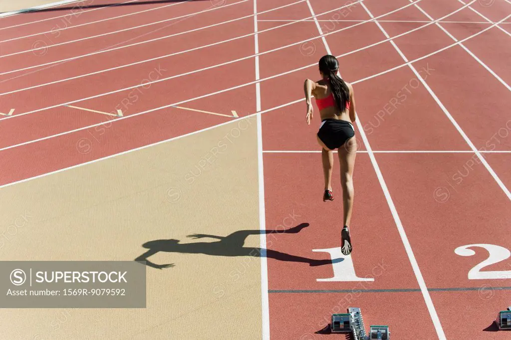 Woman running on track, rear view