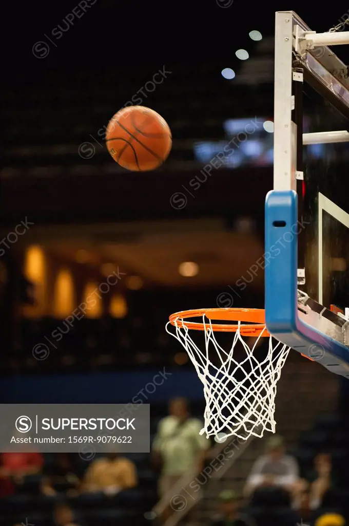 Basketball in midair above basketball hoop