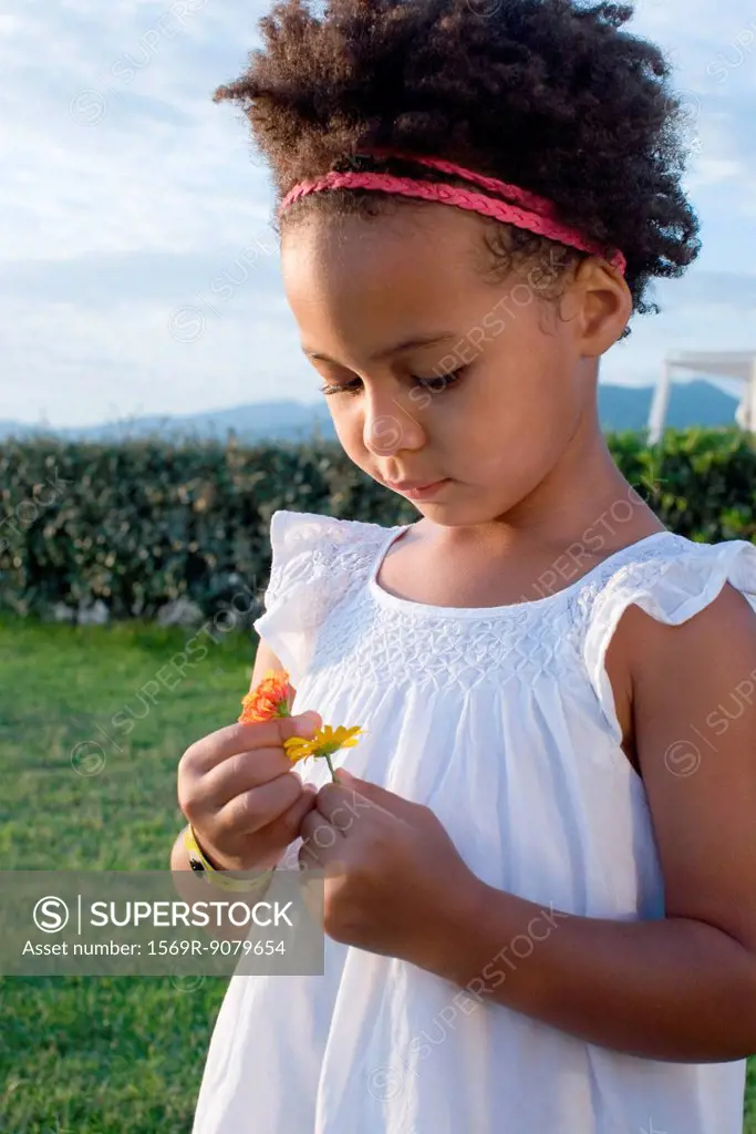 Little girl looking at flowers
