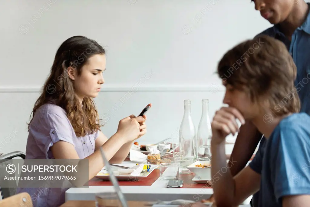 Young woman text messaging in restaurant