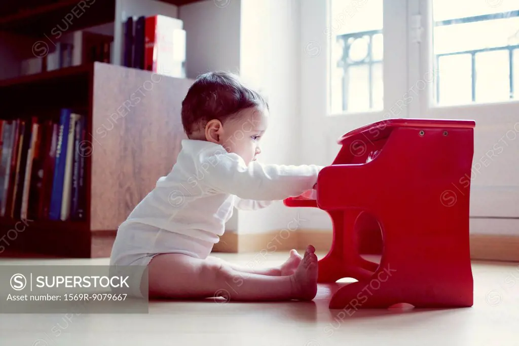 Infant playing with toy piano