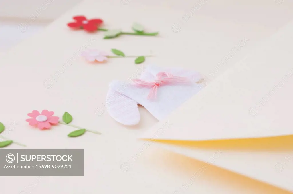 Stationery embellished with miniature baby clothing and flowers