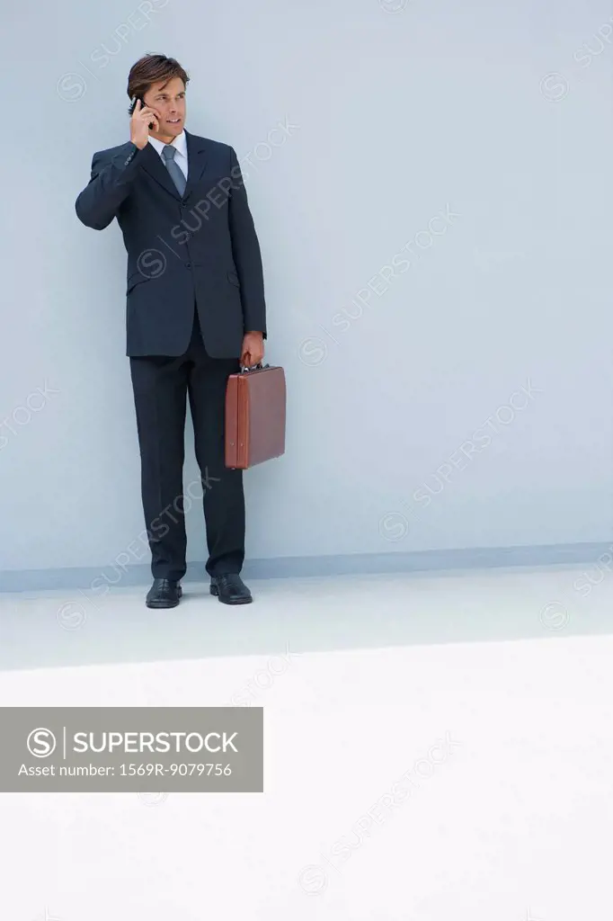 Businessman using cell phone outdoors