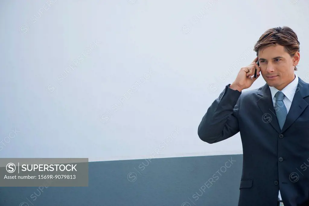 Businessman using cell phone outdoors