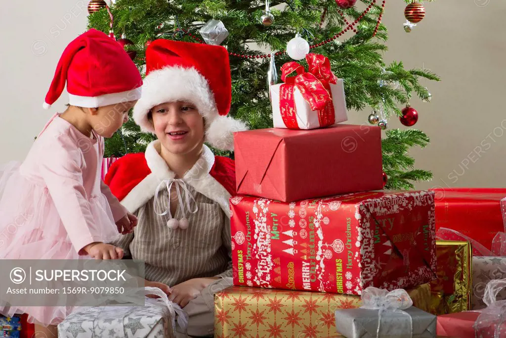 Young brother and sister preparing to open Christmas presents
