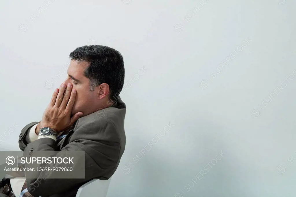 Businessman covering face with hands