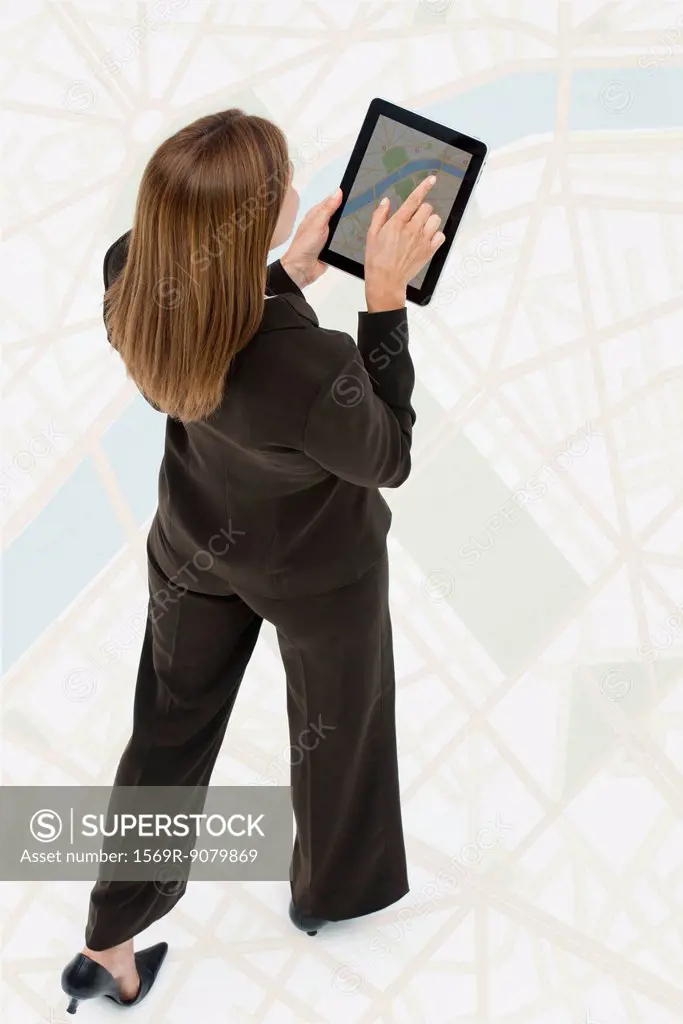Woman looking at map on digital tablet while walking on large map