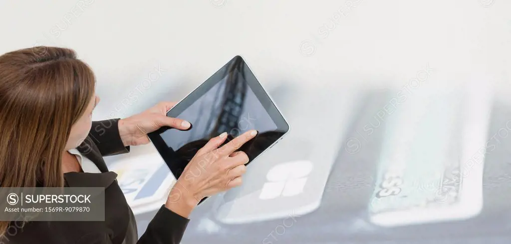 Woman using digital tablet, image of wallet containing credit cards superimposed on background