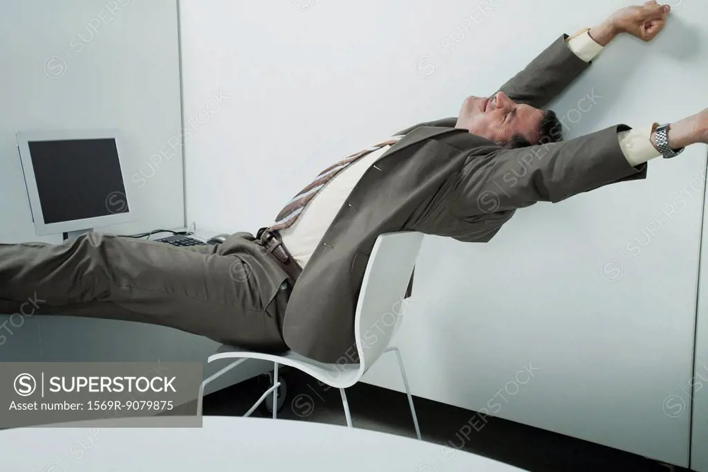 Businessman stretching at desk