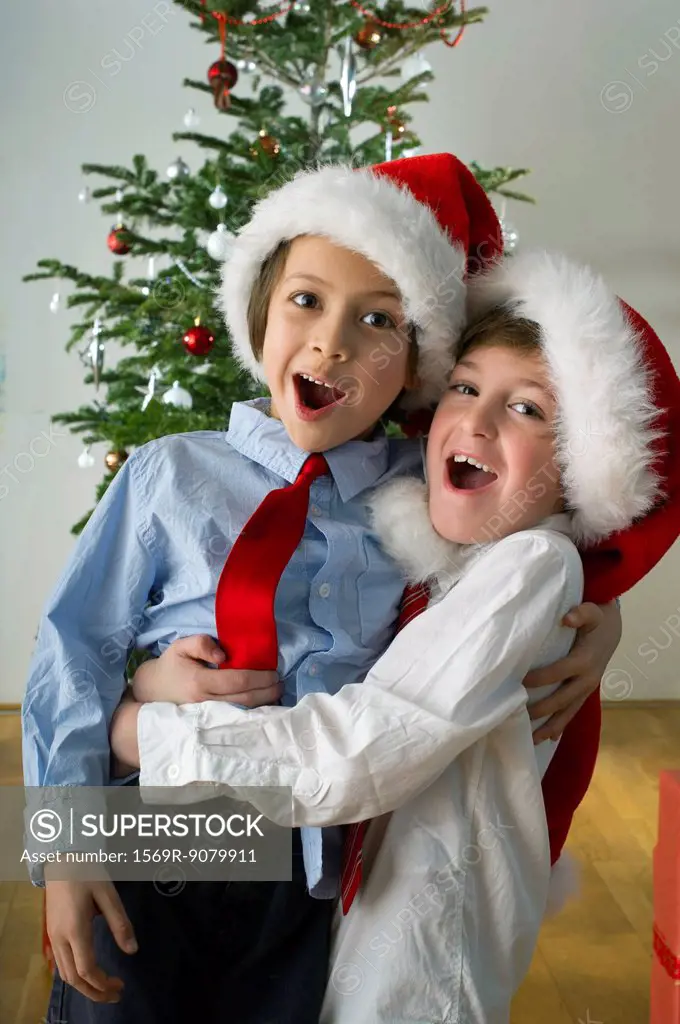 Young friends wearing Santa hats and embracing on Christmas