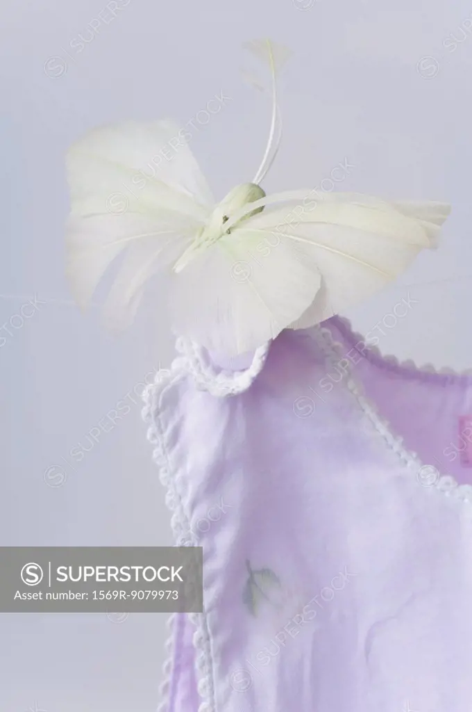 Fake butterfly resting on shoulder of baby clothing